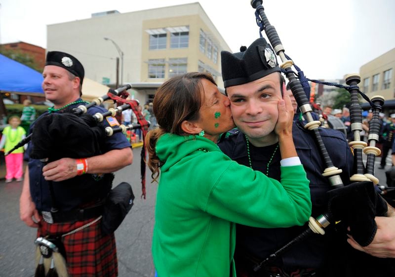 Brenda Meyers kisses a member of the Yonkers New York Fire Department Pipe and Drum during Savannah's St. Patrick's Day Parade in 2014. Kissing men in uniform is a tradition during the celebration, although U.S. soldiers are off-limits. (AP Photo/Stephen B. Morton)