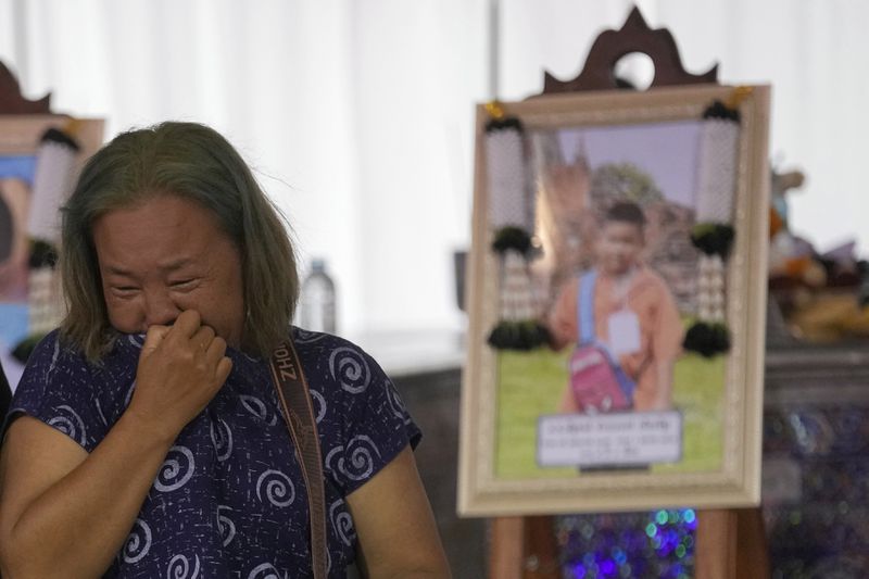 A relative wails near the coffin of a victim of school bus fire at Wat Khao Phraya Sangkharam School Lan Sak, Uthai Thani province, Thailand, Thursday, Oct. 3, 2024. (AP Photo/Sakchai Lalit)