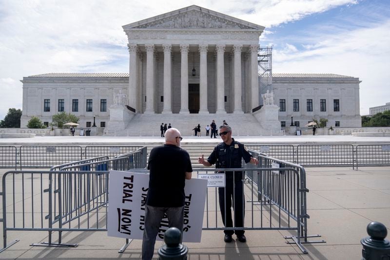 A Supreme Court police officer talks with a demonstrator at a barricade outside the Supreme Court on Thursday, June 27, 2024, in Washington. (AP Photo/Mark Schiefelbein)