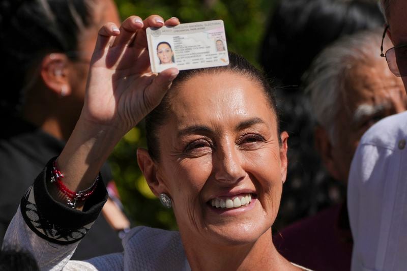 Ruling party presidential candidate Claudia Sheinbaum shows her ID as she leaves a polling station where she voted during general elections in Mexico City, Sunday, June 2, 2024. Mexico’s next president and its first female leader in more than 200 years of independence, Sheinbaum captured the post by promising continuity, emerging victorious early Monday. (AP Photo/Marco Ugarte)