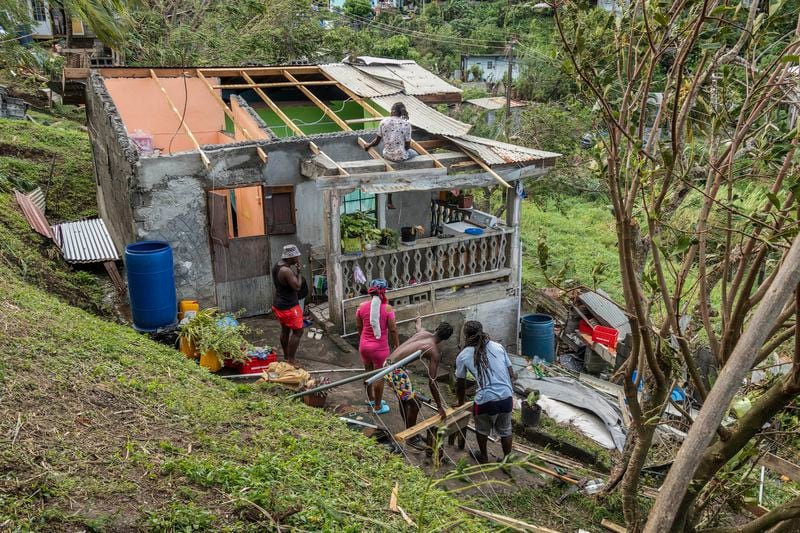 Family members begin to repair their home damaged in the passing of Hurricane Beryl, in Ottley Hall, St. Vincent and the Grenadines, Tuesday, July 2, 2024. (AP Photo/Lucanus Ollivierre)