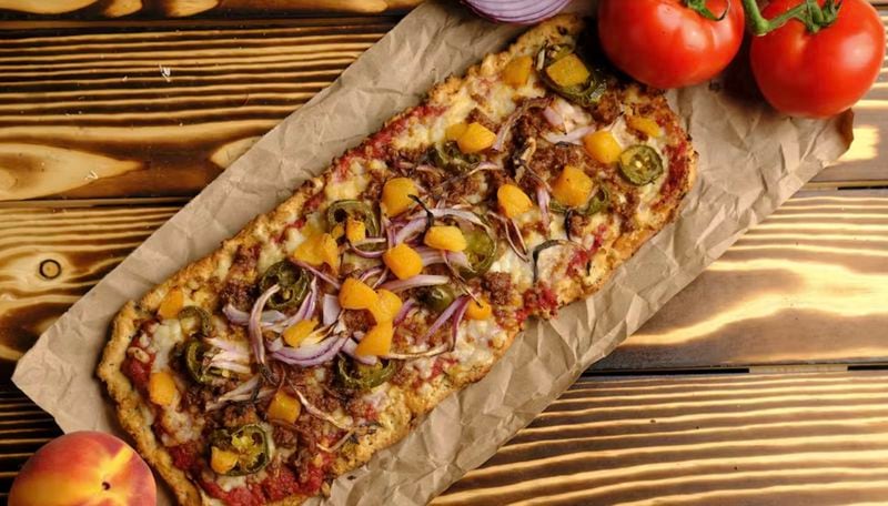 The vegan Plant-Based Pizzeria serves a Georgia peach pizza, topped with spicy Beyond sausage, jalapeños, and peaches. (Courtesy of Plant-Based Pizzeria)