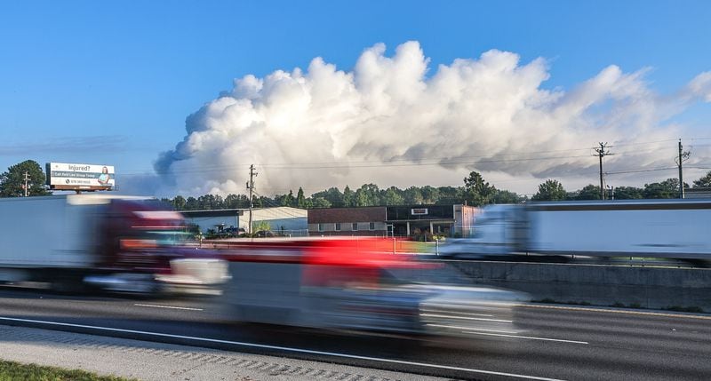 The large plume of smoke from a  chemical plant fire on Sunday is still visible from I-20 eastbound near West Avenue in Conyers on Monday morning. (John Spink / AJC)