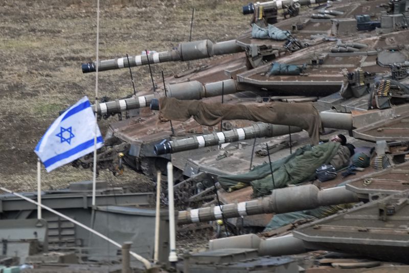 Israeli soldiers sleep on tanks in a staging area in northern Israel near the Israel-Lebanon border, Tuesday, Oct. 1, 2024. (AP Photo/Baz Ratner)