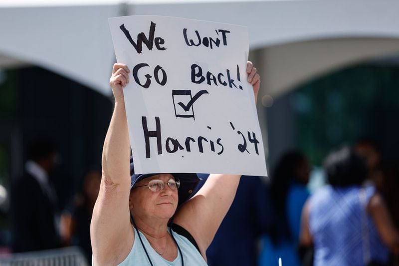 Stacey Livingston holds up a sign in support of Vice President Kamala Harris outside of the Georgia State University Convocation Center on Tuesday.