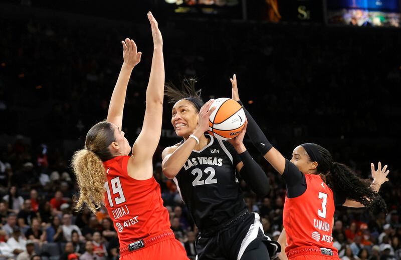 Las Vegas Aces center A'ja Wilson (22) prepares to shoot between Atlanta Dream forward Lorela Cubaj (19) and guard Jordin Canada (3) during the first half of an WNBA basketball game Friday, Aug. 30, 2024 in Las Vegas. (Steve Marcus/Las Vegas Sun via AP)