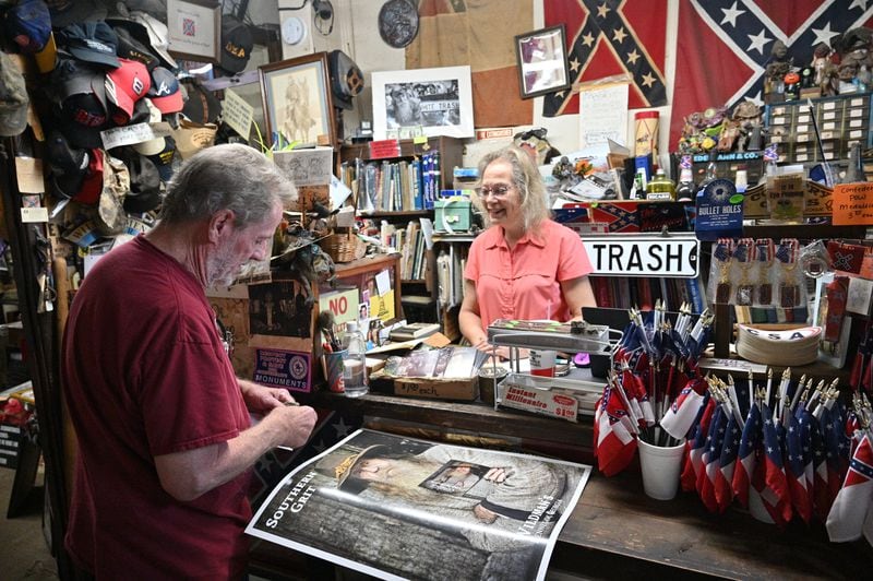 June 16, 2022 Kennesaw - Marjorie Lyon (right), the new owner, helps a longtime customer Mickey Magruder at Wildman's Civil War Surplus in Kennesaw on Thursday, June 16, 2022. The store first opened in downtown Kennesaw in 1971. When the owner, Dent Myers died in January, Marjorie Lyon vowed to keep the shop open. Councilman James “Doc” Eaton resigned from Kennesaw City Council Tuesday over the reopening of Wildman’s Civil War shop. (Hyosub Shin / Hyosub.Shin@ajc.com)