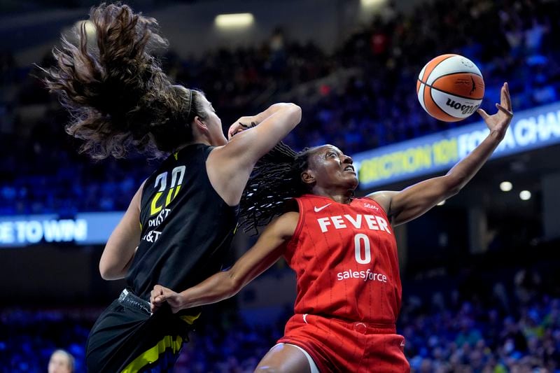 Indiana Fever guard Kelsey Mitchell (0) is blocked on a shot by Dallas Wings' Maddy Siegrist (20) in the first half of a WNBA basketball game Sunday, Sept. 1, 2024, in Arlington, Texas. (AP Photo/Tony Gutierrez)