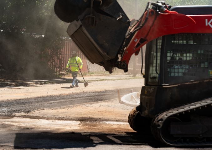 Construction workers work on William Holmes Borders Senior Drive SE and Gartrell Drive SE in Atlanta on Tuesday, June 25, 2024. (Seeger Gray / AJC)