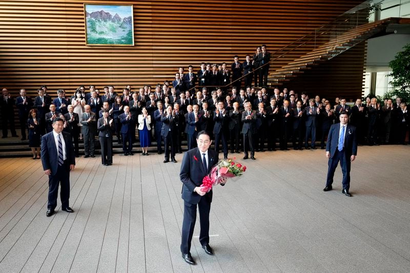 Japan's outgoing Prime Minister Fumio Kishida, center, smiles as he leaves the prime minister's office in Tokyo Tuesday, Oct. 1, 2024. (AP Photo/Hiro Komae)