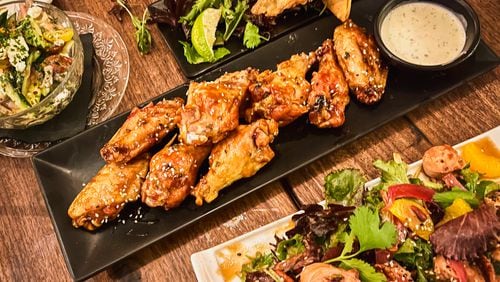 Wings, empanadas and grilled octopus with mixed greens are among the options at Marietta Proper. Henri Hollis/henri.hollis@ajc.com