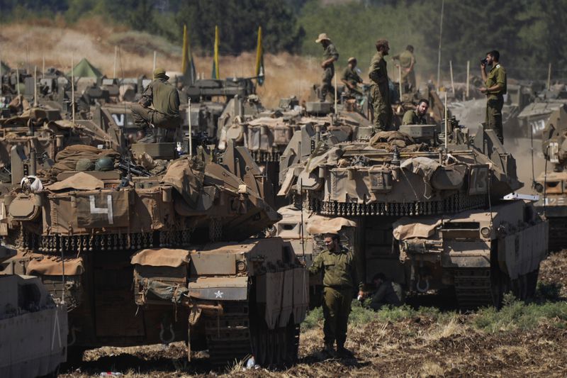 Israeli soldiers work on tanks in northern Israel on Friday, Sept. 27, 2024. (AP Photo/Baz Ratner)