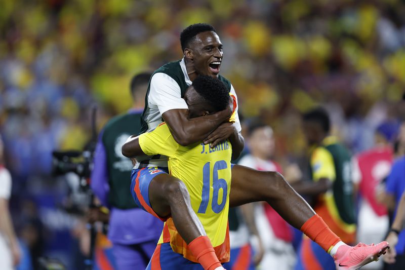 Colombia's Jefferson Lerma (16) celebrates with a teammate their team's 1-0 victory over Uruguay at the end of a Copa America semifinal soccer match in Charlotte, N.C., Wednesday, July 10, 2024. (AP Photo/Nell Redmond)