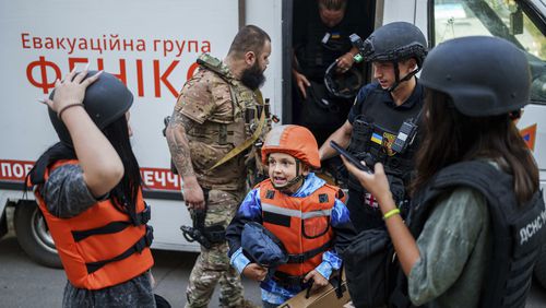 Bohdan Scherbyna, 9, with his mother Maryna Scherbyna, 45, and sister Angelina Scherbyna, 14, left, on Aug. 20 Pokrovsk, Donetsk region, as part of an evacuation of local people from Selidove to safe areas. (Evgeniy Maloletka/AP)