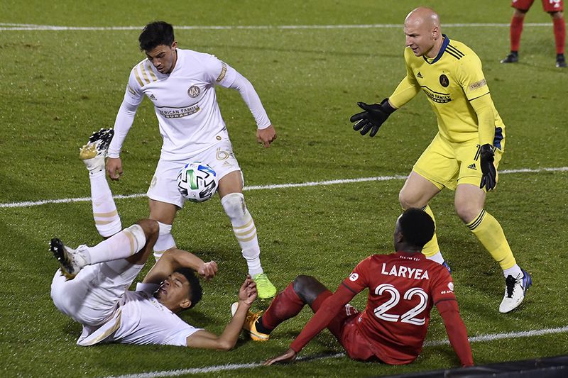 Toronto FC's Richie Laryea (bottom right), falls over Atlanta United's Miles Robinson on a drive to the goal as Atlanta United's Fernando Meza (top lef), and goalkeeper Brad Guzan (right) defend during the second half Sunday, Oct. 18, 2020, in East Hartford, Conn. (Jessica Hill/AP)