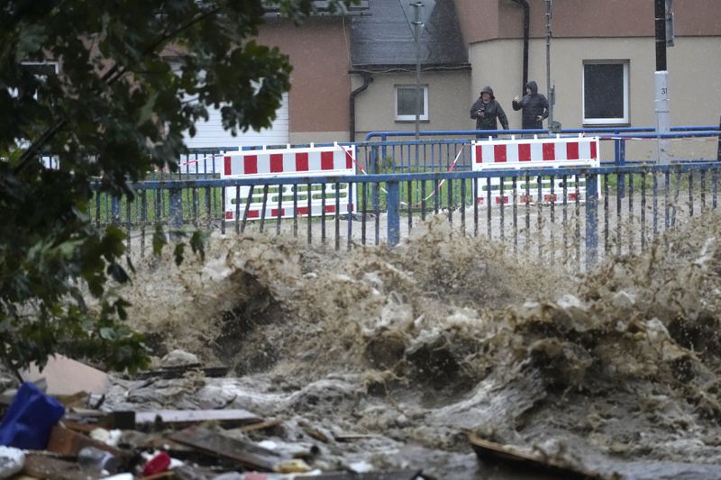 Residents watch the river during floods Jesenik, Czech Republic, Sunday, Sept. 15, 2024. (AP Photo/Petr David Josek)