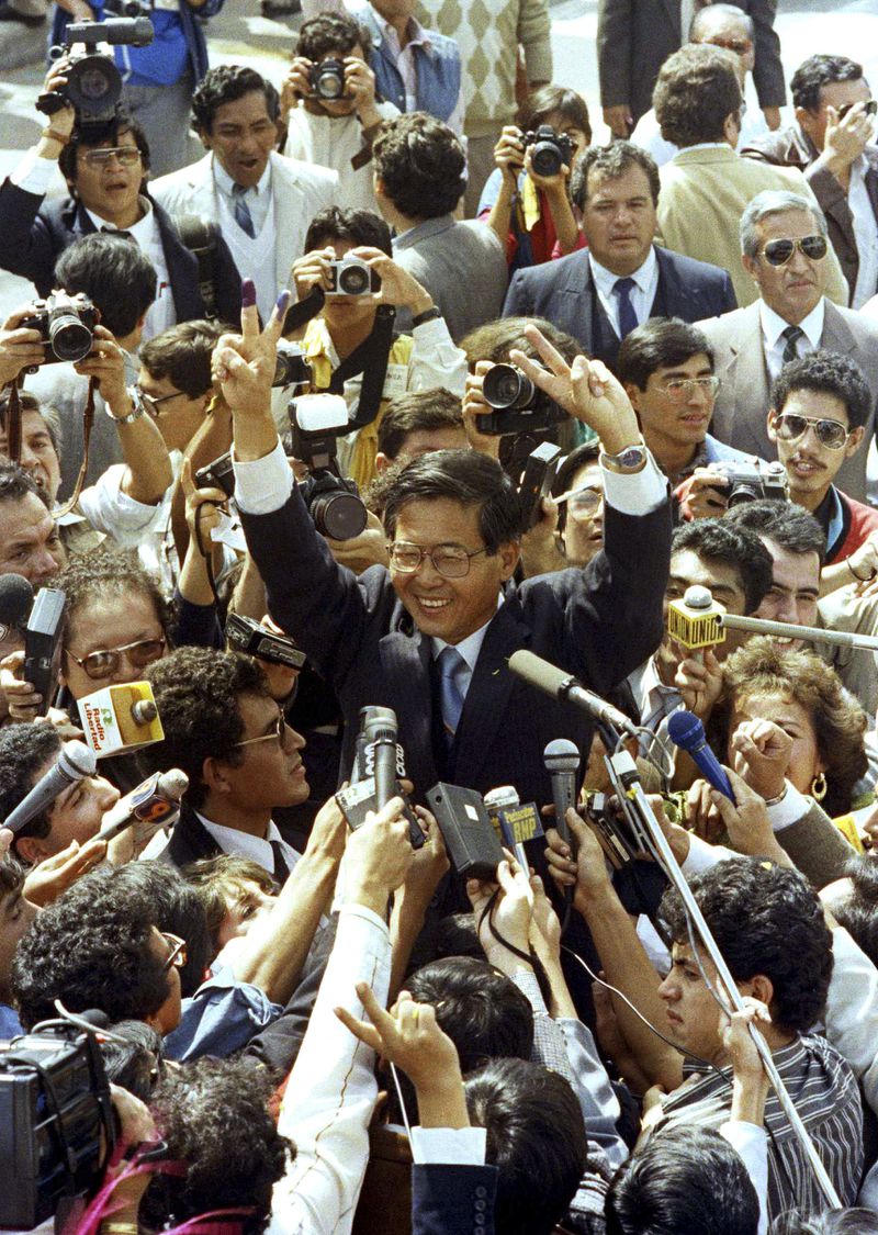 FILE - Presidential candidate Alberto Fujimori waves to supporters after casting his vote during a presidential runoff against novelist Mario Vargas Llosa in Lima, Peru, June 10, 1990. (AP Photo/Matias Recart, File)