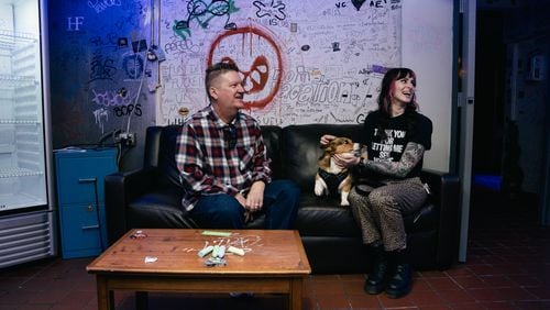 Greg Green, general manager, and Elena de Soto, talent buyer and photographer at the Masquerade music venue in Underground Atlanta, sit with Elena's corgi who is lovingly known as "Punk Rock Milo" by his 10,000+ followers on Instagram, on Friday, March 8, 2024. (Olivia Bowdoin for the AJC).