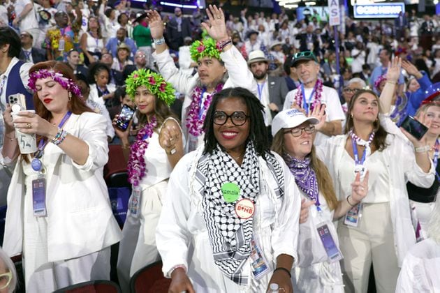 Delegates dressed in white hold their hands over their hearts during the pledge of allegiance at the start of the fourth day of the Democratic National Convention in Chicago on Thursday, Aug. 22, 2024. (Arvin Temkar/ AJC )