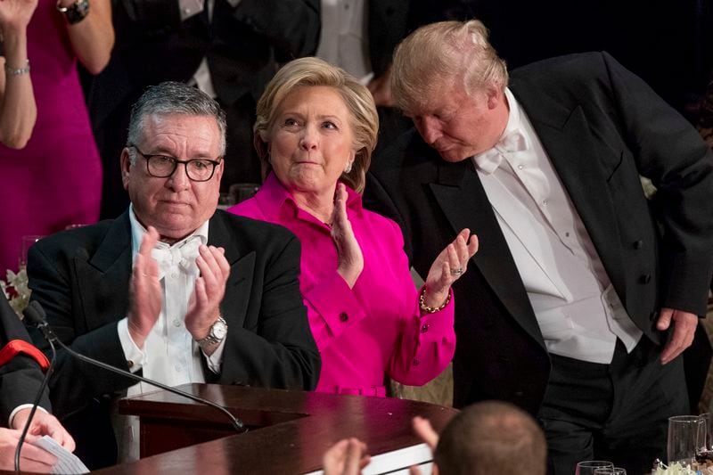 FILE - From left, Alfred E. Smith IV, Democratic presidential candidate Hillary Clinton, and Republican presidential candidate Donald Trump stand to applaud during the 71st annual Alfred E. Smith Memorial Foundation Dinner, Thursday, Oct. 20, 2016, in New York. (AP Photo/Andrew Harnik, File)