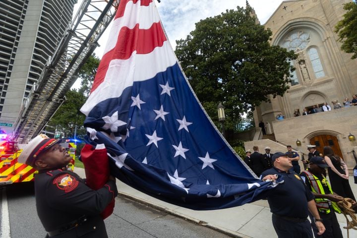 Atlanta Fire Rescue honor guard, Lt. Michael Williams (left) and firefighter, Robert Piccini (right prepare to hoist a giant American flag from ladder trucks as first responders and police were in attendance at the Cathedral of Christ the King located at 2699 Peachtree Road NE in Buckhead for the Annual Blue Mass honoring safety officials and first responders. Atlanta Mayor Andre Dickens along with Atlanta Rescue Fire and Atlanta Police were in attendance to join parishioners and members of the public to pray and show appreciation for those who serve and protect the public in observance of 9-11.