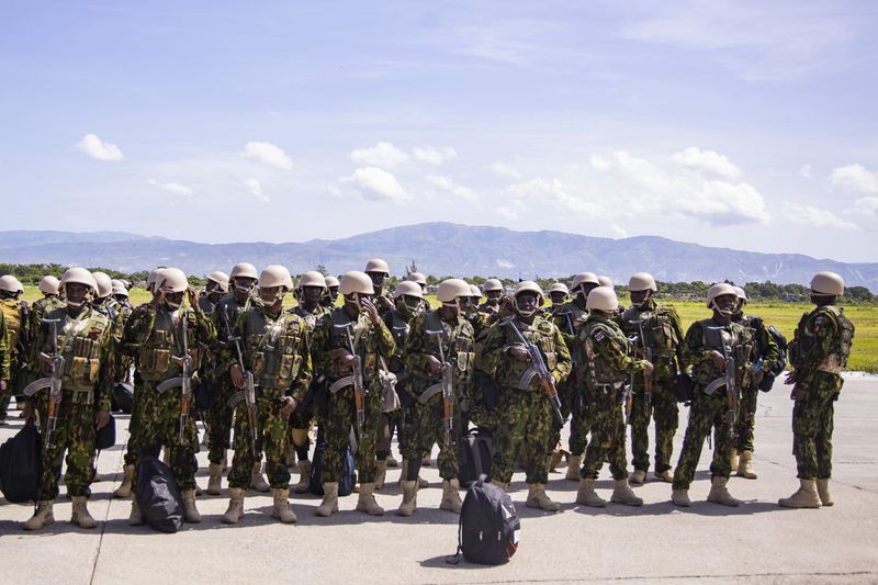 Police from Kenya stand at the Toussaint Louverture International Airport after landing in Port-au-Prince, Haiti, Tuesday, June 25, 2024. The first U.N.-backed contingent of foreign police arrived nearly two years after the Caribbean country requested help to quell a surge in gang violence. (AP Photo/Marckinson Pierre)