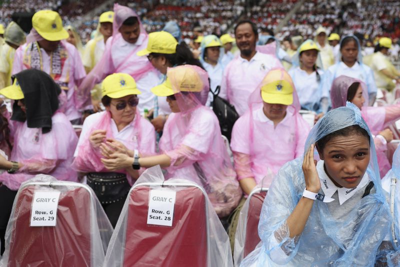 Catholic worshipers wear raincoats while attending the holy mass at a Gelora Bung Karno Stadium in Jakarta, Indonesia, Thursday, Sept. 5, 2024, as Pope Francis is visiting the country. (Ajeng Dinar Ulfiana/Pool Photo via AP)