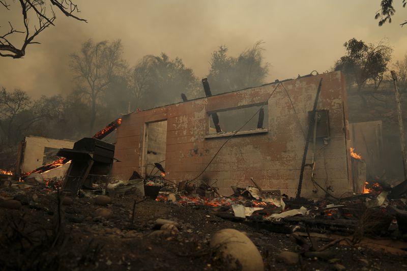 A structure burns after the Airport Fire swept through Tuesday, Sept. 10, 2024, in El Cariso, an unincorporated community in Riverside County, Calif. (AP Photo/Eric Thayer)