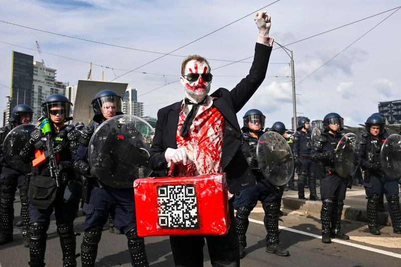 A protester gestures as Victorian police clash with anti-war protesters outside a military arms convention in downtown Melbourne, Australia, Wednesday, Sept. 11, 2024. (Joel Carrett/AAP Image via AP)