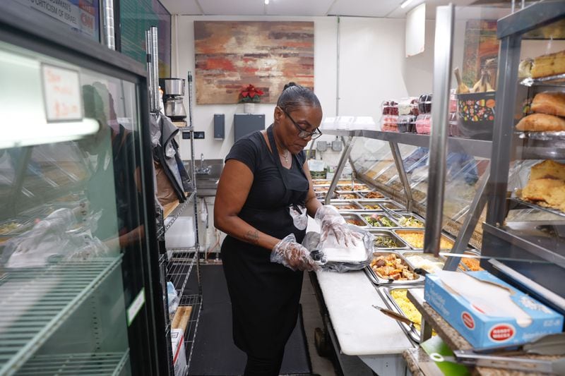 Sharon Marshall, a server at West End Soul Food Kitchen prepares a plate for a customer on Tuesday, June 4, 2024. The restaurant is one of the many businesses in West End that was negatively impacted by the city’s water main break. (Natrice Miller/AJC)(Natrice Miller/ AJC)