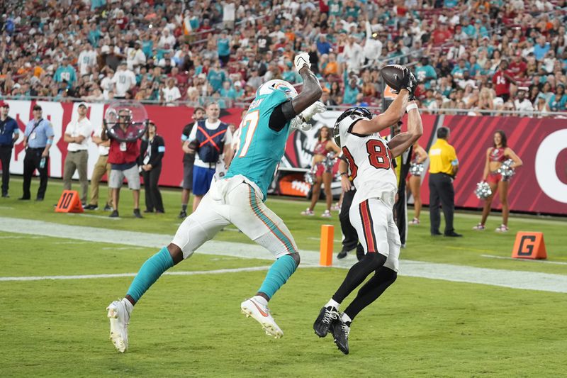 Tampa Bay Buccaneers wide receiver Tanner Knue (80) grabs a touchdown pass ahead of Miami Dolphins cornerback Isaiah Johnson (37) during the second half of a pre season NFL football game, Friday, Aug. 23, 2024, in Tampa, Fla. (AP Photo/Chris O'Meara)