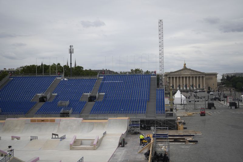 Constructions work takes place at the Concorde olympic venue and the National Assembly, right, on Wednesday, July 3, 2024 in Paris. Just three weeks before the Olympics, the excitement that was building up in the host city has mingled with anxiety about France’s political future. (AP Photo/Thibault Camus)