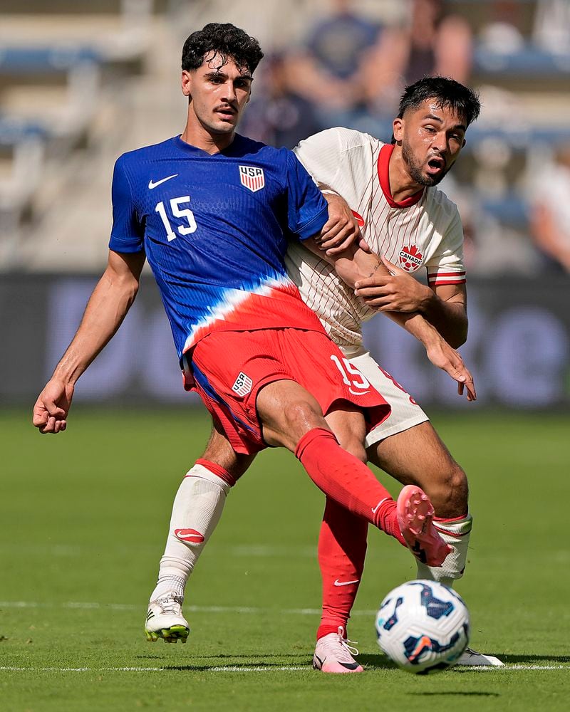 United States midfielder Johnny Cardoso (15) kicks the ball under pressure from Canada midfielder Mathieu Choiniere during the first half of an international friendly soccer game, Saturday, Sept. 7, 2024, in Kansas City, Mo. (AP Photo/Charlie Riedel)