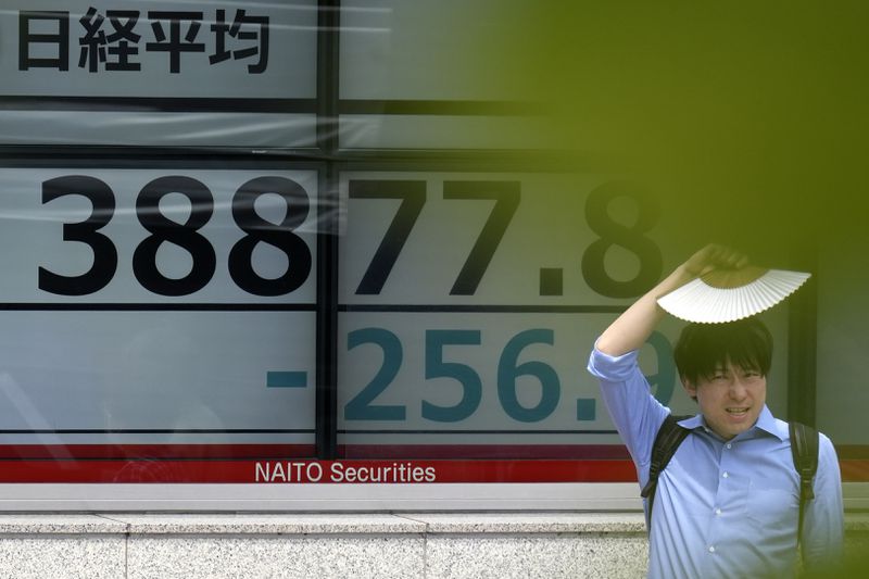 A person stands in front of an electronic stock board showing Japan's Nikkei 225 index at a securities firm on June 12, 2024, in Tokyo. (AP Photo/Eugene Hoshiko)