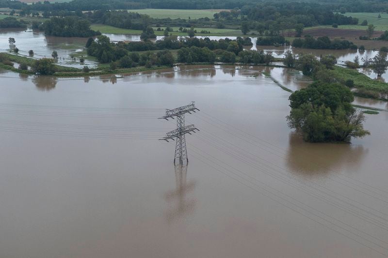 An electricity pylon stands in the flood waters of the Neisse, in the Hagenwerder district of Görlitz, Germany, Monday, Sept. 16, 2024. (Paul Glaser/dpa via AP)