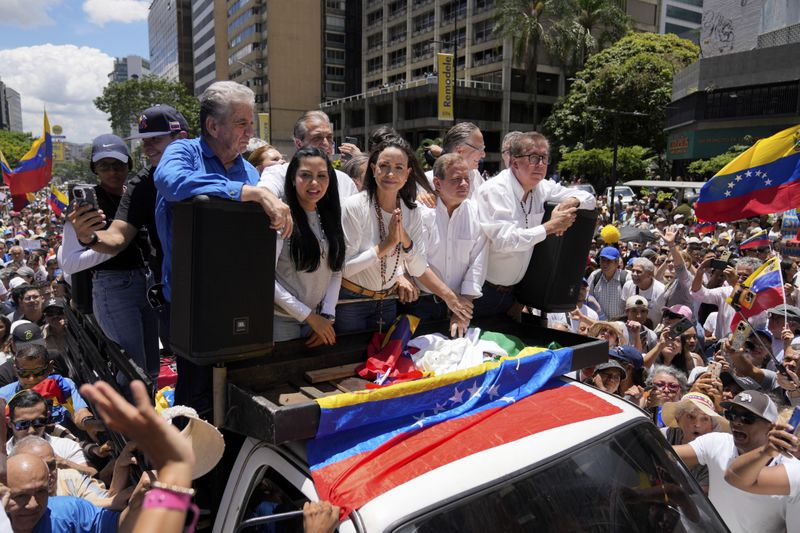 Maria Corina Machado, center, leads a protest against the reelection of President Nicolás Maduro one month after the disputed presidential vote which she claims the opposition won by a landslide, in Caracas, Venezuela, Wednesday, Aug. 28, 2024. (AP Photo/Ariana Cubillos)