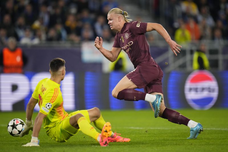 Manchester City's Erling Haaland takes the ball past Slovan's goalkeeper Dominik Takac to score his side's throw goal during the Champions League opening phase soccer match between Slovan Bratislava and Manchester City in Bratislava, Slovakia, Tuesday, Oct. 1, 2024. (AP Photo/Petr Josek)