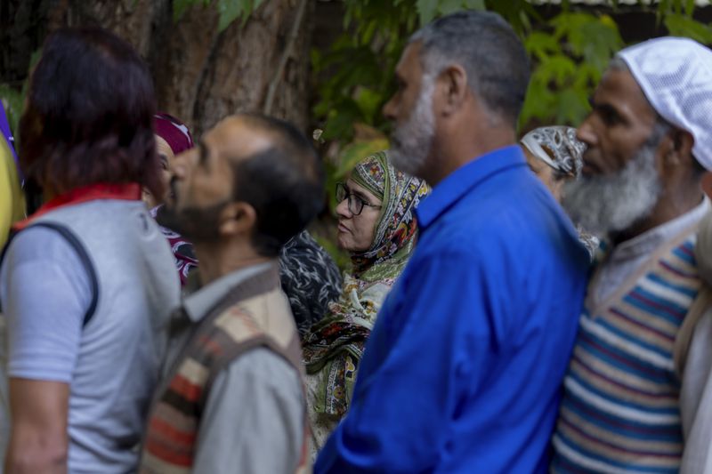 People queue up at a polling booth to cast their vote in Naira, south of Srinagar, Indian controlled Kashmir, Wednesday, Sept. 18, 2024. (AP Photo/Dar Yasin)