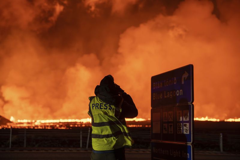 Photographers and journalists on location filming and reporting on the new fissure north of Grindavik, Iceland, Thursday, Aug. 22, 2024, (AP Photo/Marco di Marco)