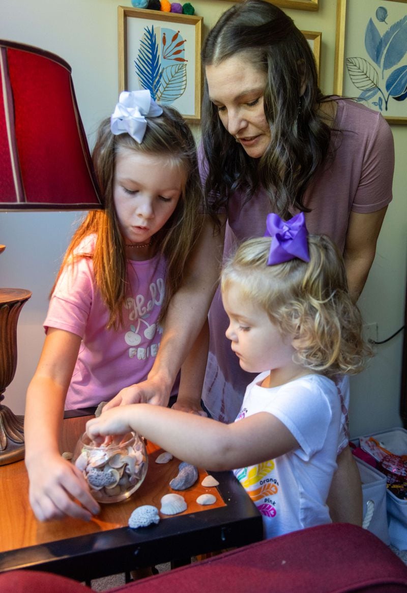  Emberly Burns (from left), her mother Amber and sister Amelia go through their sea shell collection in their apartment in Atlanta. PHIL SKINNER FOR THE ATLANTA JOURNAL-CONSTITUTION