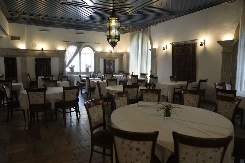 A dining room at the American Colony Hotel in east Jerusalem, Sunday, Aug. 18, 2024. As Israel’s economy is suffering from the nearly 11-month war with Hamas, Jerusalem’s iconic American Colony hotel has had to lay off workers and are mulling pay cuts, said Jeremy Berkovitz, the official representative of the owners. (AP Photo/Mahmoud Illean)