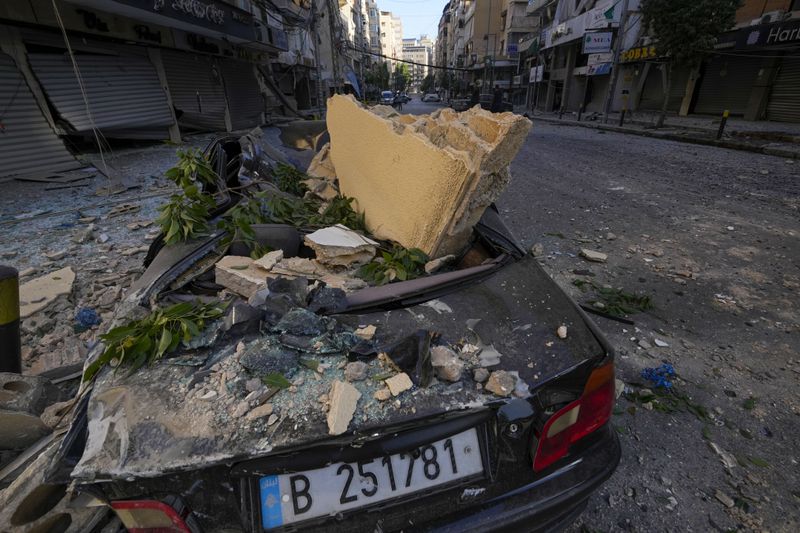 A wrecked car parked next to the site of an Israeli airstrike in Dahiyeh, Beirut, Lebanon, Thursday, Oct. 3, 2024. (AP Photo/Hassan Ammar)