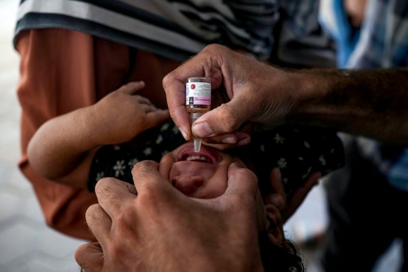 A health worker administers a polio vaccine to a child at a hospital in Deir al-Balah, central Gaza Strip, Sunday, Sept. 1, 2024. (AP Photo/Abdel Kareem Hana)