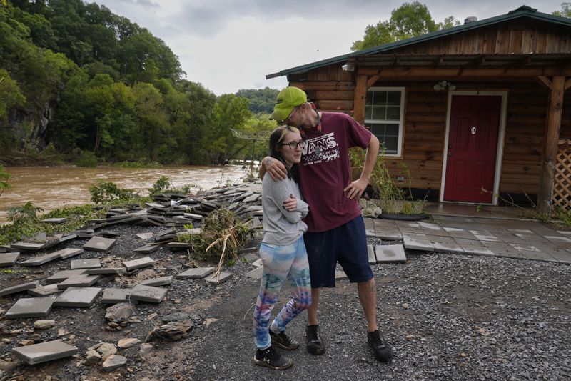 FILE - Jonah Wark, right, kisses his wife Sara Martin outside their flood-damaged home on the Pigeon River in the aftermath of Hurricane Helene, Sept. 28, 2024, in Newport, Tenn. (AP Photo/George Walker IV, File)