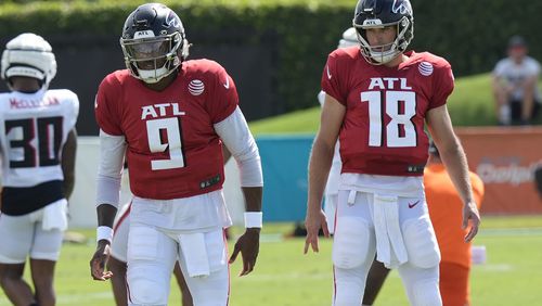 Atlanta Falcons quarterbacks Michael Penix Jr., (9) and Kirk Cousins (18) watch drills during a joint NFL football practice with the Miami Dolphins at the team's practice facility, Tuesday, Aug. 6, 2024, in Miami Gardens, Fla. (AP Photo/Marta Lavandier)