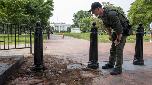 FILE - A U.S. Park Police officer inspects a security barrier for damage in Lafayette Square park near the White House, May 23, 2023, in Washington. A Missouri man pleaded guilty Monday, May 13, 2024, to crashing a rented truck into White House barriers last year. Sai Varshith Kandula drove a large U-Haul truck onto a sidewalk, sending pedestrians running for safety, before ramming it into metal bollard barriers that prevent vehicles from entering Lafayette Square. (AP Photo/Alex Brandon, File)