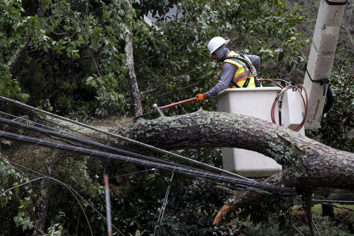 A Worker cuts branches from a fallen tree that knocked out power to a neighborhood in Decatur on Friday, Sept. 27, 2024 following a night of heavy rain from Hurricane Helene. Ben Gray for the Atlanta Journal-Constitution