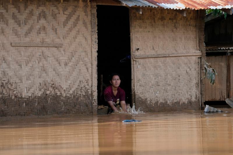 A local resident washes clothes on a flooded road in Naypyitaw, Myanmar, Sunday, Sept. 15, 2024. (AP Photo/Aung Shine Oo)