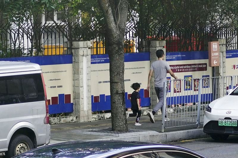 People walk past the Shenzhen Japanese School in Shenzhen, China Wednesday, Sept. 18, 2024, where a 10-year-old Japanese student was stabbed by a man. (Kyodo News via AP)