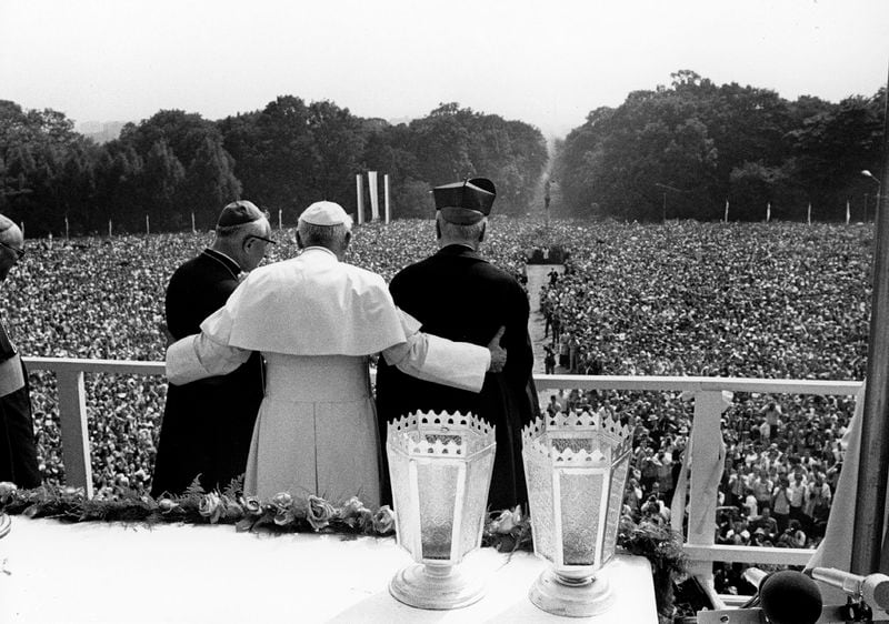 FILE - Pope John Paul II. has his arms around the Primate of Poland, Stefan Cardinal Wyszynski, right, and the Bishop of Czestochowa, Stanislaw Barela, as he faces huge crowd of faithful outside the Jasna Gora monastery, Czestochowa, on June 4, 1979, where the Pontiff holds a pontifical mass on his third day of his nine-day-visit to his homeland Poland. (AP Photo, File)